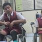 Siswa SD 2 Kesiman saat menerima bantuan kursi roda dan meja belajar dari PT HRP Logistics. ®okedailybali